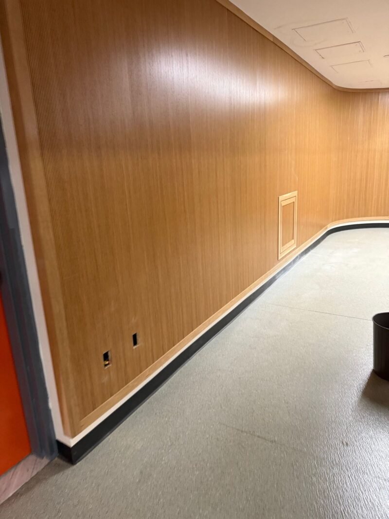 Long continuous wood-paneled corridor wall