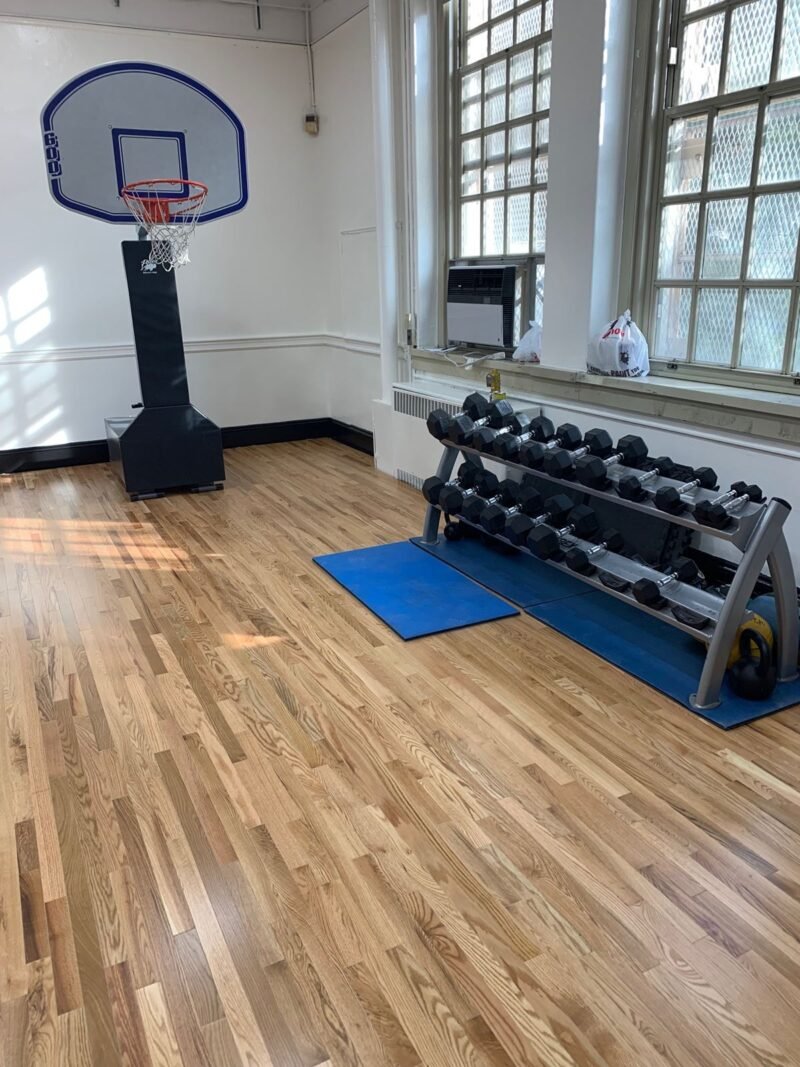Fitness room with new oak strip flooring, weight rack and basketball hoop