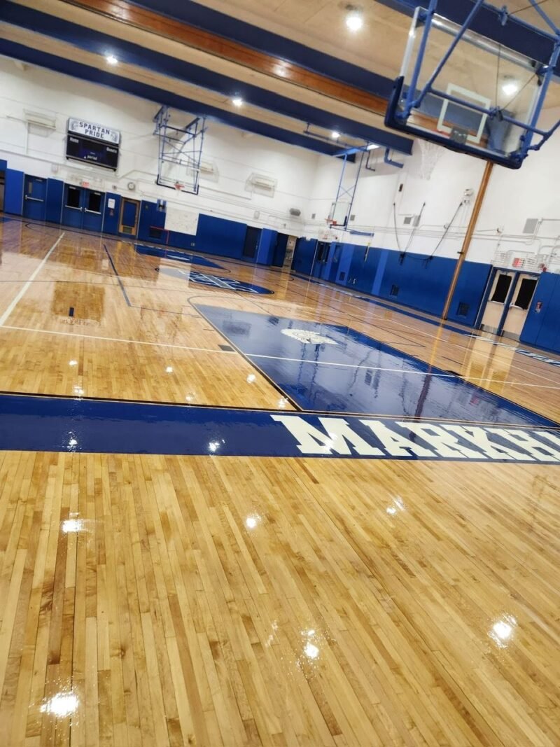 Glossy gymnasium floor with navy key and blue wall padding