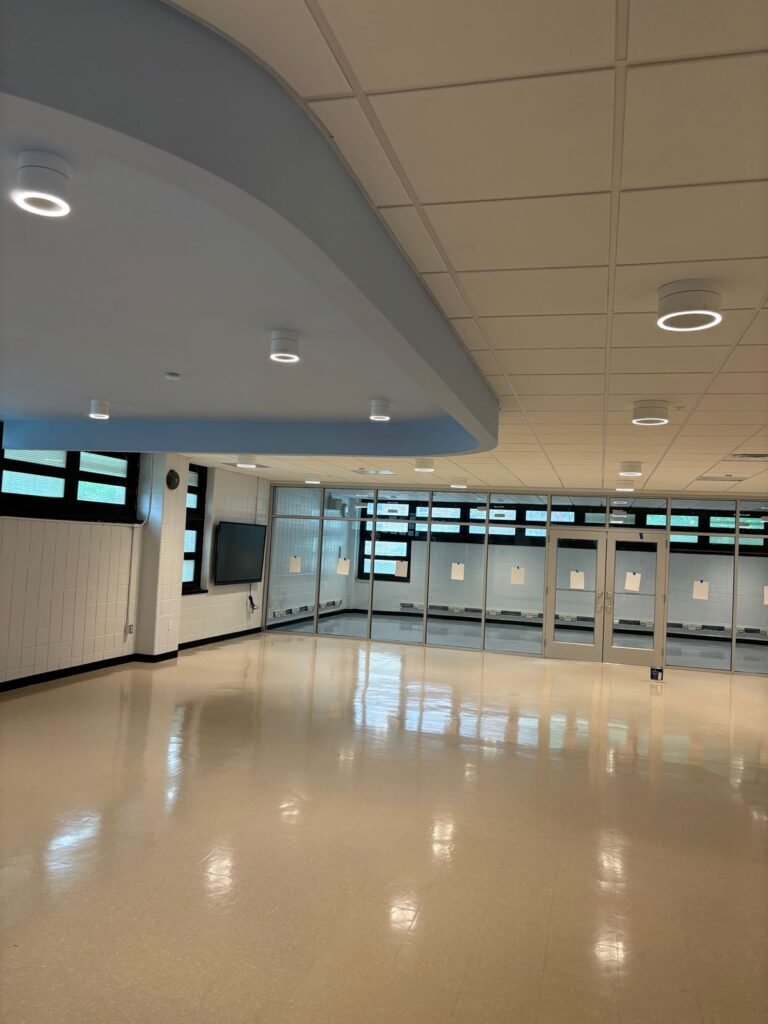 Multipurpose room with curved blue soffit and glazed partition wall