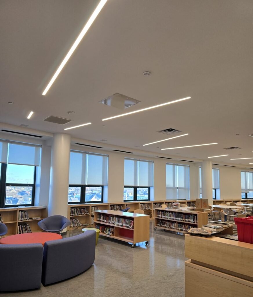 Library with linear LED lights, rolling bookcases and lounge seating