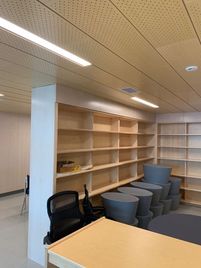 Library fit-out with maple shelving, stacked stools and wood ceiling